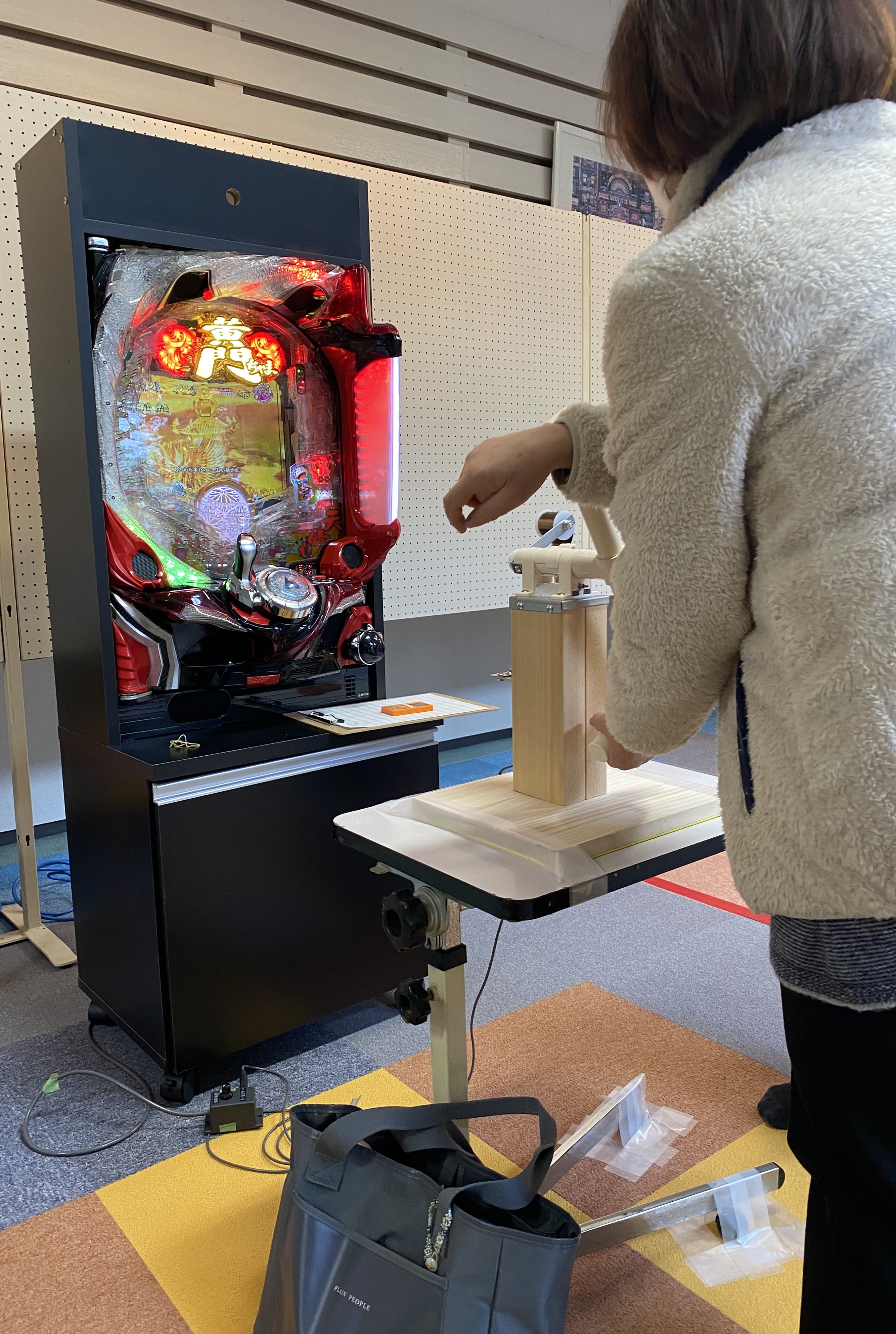 補助器具を使って介護予防用パチンコを操作している様子（操作サポート）